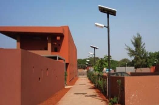 Lampadaires solaires le long d'une allée, entre des murs ocre