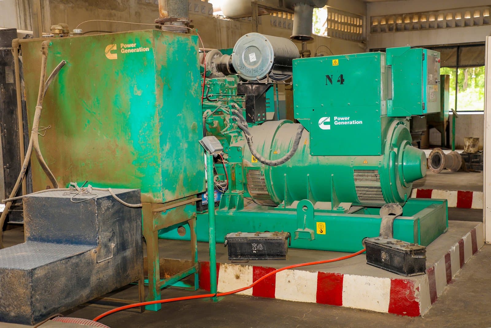 Moteur Cummins et alternateur posés sur leur châssis dans l'atelier